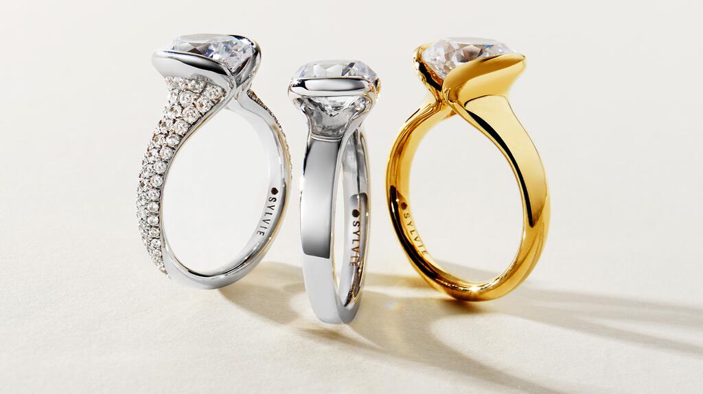 From left to right, the “Mariselle” ring in 14-karat white gold with diamond pavé “Shell Tip” silhouettes ($5,250), the “Jaci” ring in 14-karat white gold with a “Vista” half-bezel ($2,010), and the “Liora” solitaire ring in 14-karat yellow gold ($2,600) Sylvie Jewelry Shell Auranova Mariselle, Jaci, Liora Engagement Rings