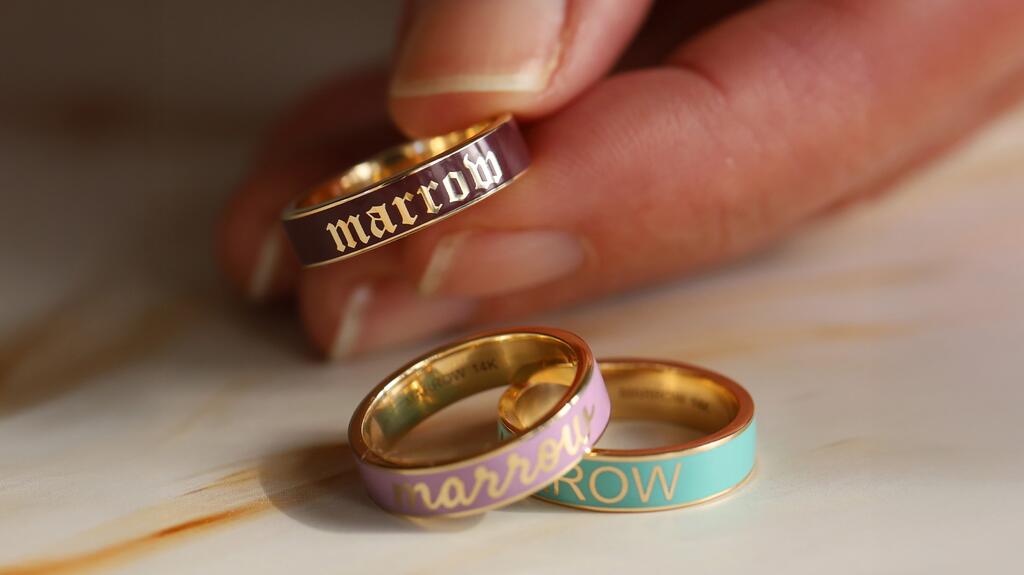 Three custom 14-karat yellow gold rings (from top to bottom) in luxardo red enamel with the old English font, in lilac enamel with the script font, and in seafoam enamel with the block font ($1,400) Marrow Fine Personalized Enamel Ring Program