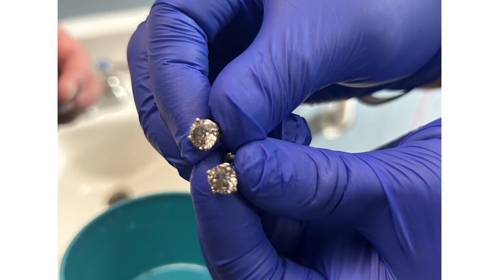 Detectives had to stand by waiting at the hospital for the earrings to be expelled, said Orlando Police Detective Aaron Goss. They were then cleaned and identified by a master jeweler at Tiffany & Co. Earrings held in gloved hand