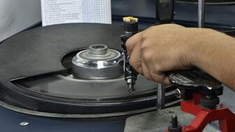 A Venus Jewel employee polishing a diamond on a wheel at the company’s facility in Surat, India. The company, a leading manufacturer of natural diamonds, is one of a number of big companies that has had to shift focus to cope with current market realities. Diamond on polishing wheel Venus Jewel India