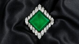 The Cartier brooch showcases a 37-carat, square-shaped Colombian emerald circled by a row of 20 marquise-shaped diamonds set in platinum and 18-karat yellow gold. Prince Sadruddin Aga Khan originally commissioned the piece in 1960 as a gift for his wife, Nina Dyer, before being auctioned in 1969, selling to Cleef & Arpels and later, Harry Winston. Aga Khan Emerald