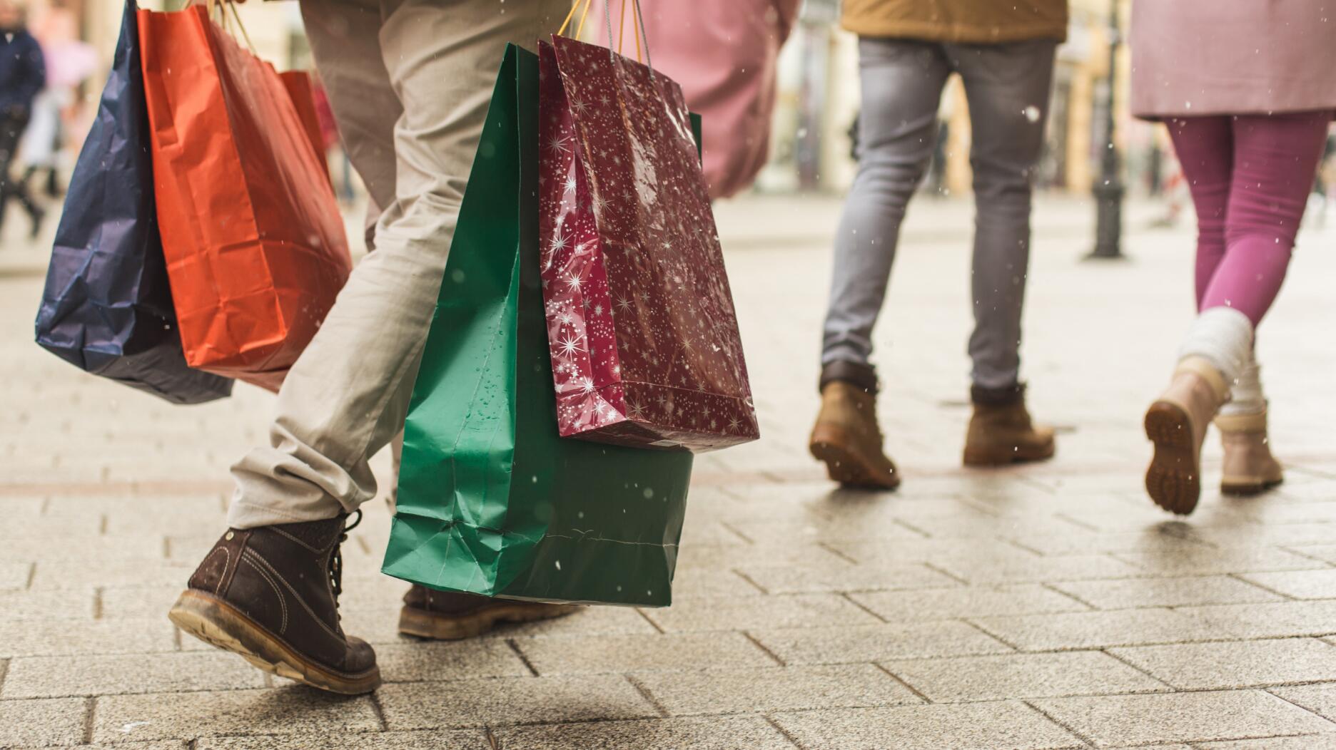 Around 126 million consumers did their holiday shopping in stores this season, up from 121.4 million last year, with Small Business Saturday faring particularly well, the National Retail Federation’s annual Thanksgiving weekend survey shows. The number of online shoppers, meanwhile, declined 7 percent. People outside holding shopping bags