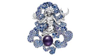 The “Diane” clip from Van Cleef & Arpels’ “Bal du Siècle, Bals de Lègende” high jewelry collection, one of the pieces soon to be on display at the American Museum of Natural History. The piece depicts Diana, the Roman goddess of the moon, in white gold floating above a purple star sapphire in a cloud of blue and mauve sapphires with a diamond crescent moon in one hand and a diamond star in the other. (Image courtesy of Van Cleef & Arpels) Van Clef & Arpels Diane (Diana) Clip