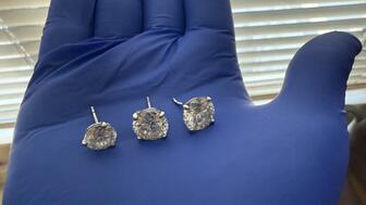 Orlando Police Department detectives recovered the earrings stolen from the Tiffany & Co. store in the Mall of Millenia on Feb. 26 and then swallowed by the man charged in the case. Three of the earrings were recovered on March 10 and the fourth on March 12. (Image courtesy of the Orlando Police Department) Diamond earrings held in gloved hand