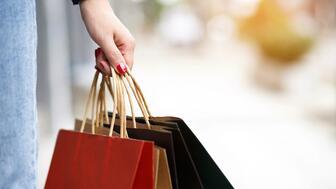 The Conference Board’s monthly consumer confidence index rose to 98 in May from 85.7 in April, following five months of consecutive decline. Woman’s hand holding shopping bags